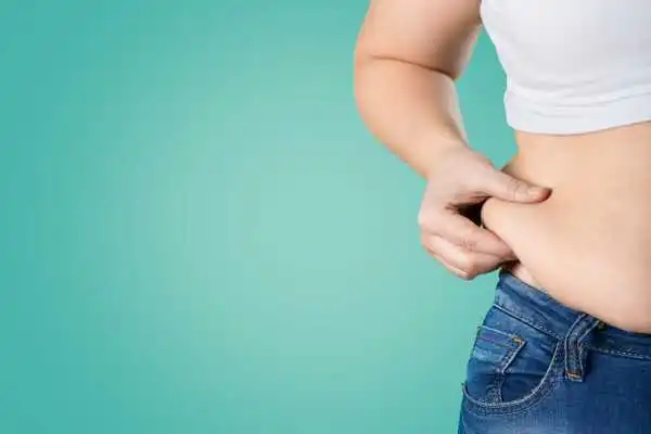 Image of woman pinching her love handles to show weight gain Fairfield